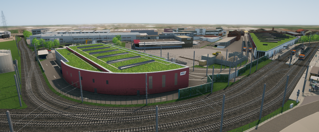 Luftaufnahme eines modernen Straßenbahn-Betriebshofs der rnv. Mehrere Gleise verlaufen um und durch das Gelände. Im Vordergrund steht ein rot verkleidetes Gebäude mit begrüntem Dach und Solarmodulen. Rechts befinden sich weitere Hallen mit Gründächern, daneben abgestellte Straßenbahnen. Das gesamte Areal ist von Industrie- und Betriebsgebäuden umgeben.