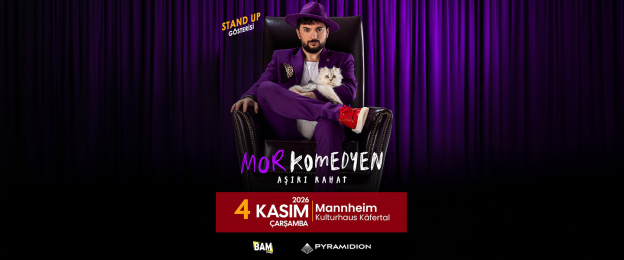 Das Veranstaltungsplakat zeigt eine Person in einem vollständig violetten Anzug mit passendem Hut auf einem dunklen Ledersessel vor einem violetten Bühnenvorhang. Auf dem Schoß der sitzenden Person liegt eine weiße Katze. Im oberen linken Bereich steht der Hinweis „Stand Up Gösterisi“. Im unteren Bereich ist der Titel der Veranstaltung „Mor Komedyen – Aşırı Rahat“ zu lesen. Darunter folgen die Veranstaltungsdaten: Mittwoch, 4. November 2026, Kulturhaus Käfertal in Mannheim. Am unteren Rand befinden sich die Logos der Veranstalter beziehungsweise Partner BAM Yapım und Pyramidion.