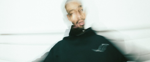 Porträtfoto zur Veranstaltung „Bruno Banarby: November Dump Vol. 2“. Eine Person in dunkler Kleidung ist mit einer bewusst unscharfen Bewegungsdarstellung vor hellem Hintergrund abgebildet.